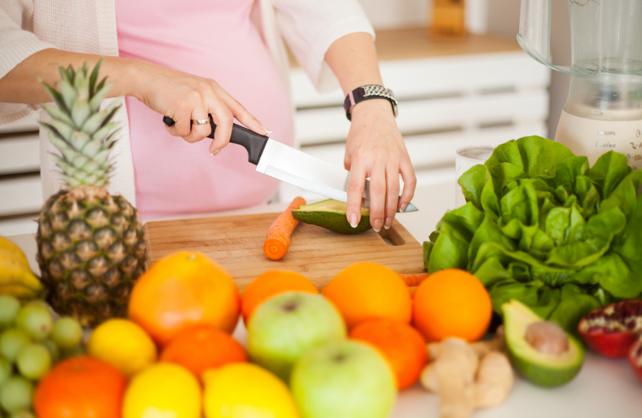 Woman in oink short cutting fruit and vegetables high in magnesium 