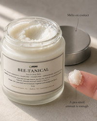 Close-up of Bee-Tanical balm's whipped texture with a pea-sized amount melting on a fingertip
