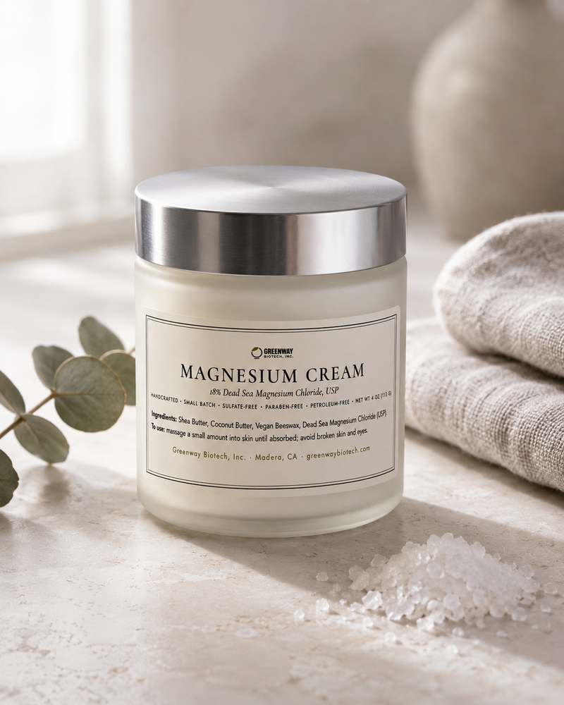 Magnesium Cream jar on pale stone with magnesium chloride flakes, a folded linen towel and eucalyptus