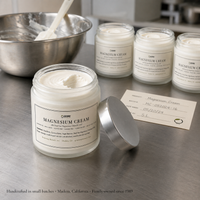 Magnesium Cream jars on a stainless workbench with a mixing bowl and batch card, handcrafted in Madera, California
