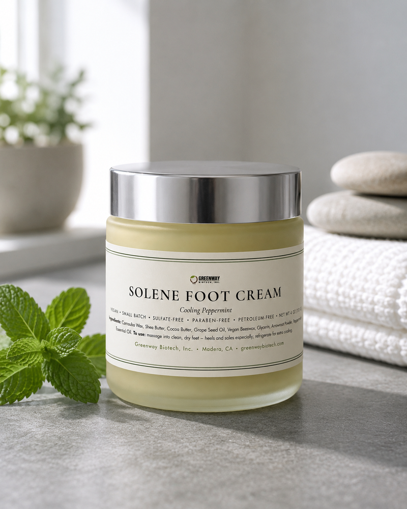 Solene peppermint foot cream jar on grey slate with fresh peppermint sprigs, river stones and a white towel